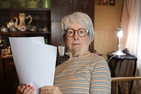 Foto de Close-up portrait of mature woman with papers at home - Imagen libre de derechos