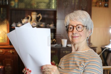 Photo for Close-up portrait of mature woman with papers at home - Royalty Free Image