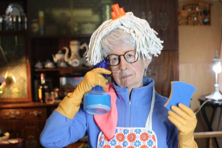 Foto de Close-up portrait of mature woman with cleaning supplies at home - Imagen libre de derechos