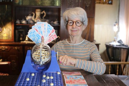Foto de Close-up portrait of mature woman with lotto game at home - Imagen libre de derechos