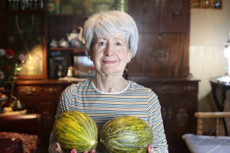 Foto de Close-up portrait of mature woman with melons at home - Imagen libre de derechos