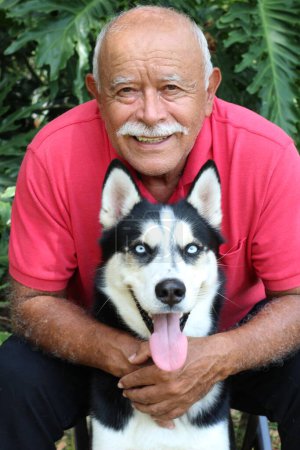 Photo for Close-up portrait of happy mature man with his husky dog in park - Royalty Free Image