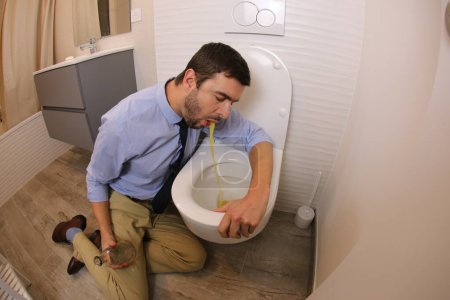 Photo for Wide angle shot of young man vomiting in toilet - Royalty Free Image