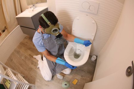 Téléchargez les photos : Plan grand angle de jeune homme nettoyage toilettes - en image libre de droit