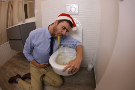 Foto de Wide angle shot of young man vomiting in toilet - Imagen libre de derechos
