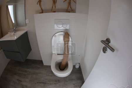 Téléchargez les photos : Plan grand angle du bras en plastique qui sort de la toilette - en image libre de droit