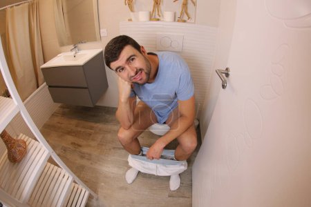 Foto de Wide angle shot of young man in toilet - Imagen libre de derechos