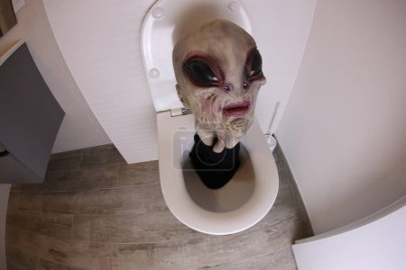Photo for Wide angle shot of alien head sticking out of toilet, comedy concept - Royalty Free Image