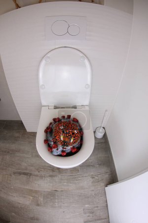 Téléchargez les photos : Wide angle shot of corona virus cell in toilet, comedy concept - en image libre de droit