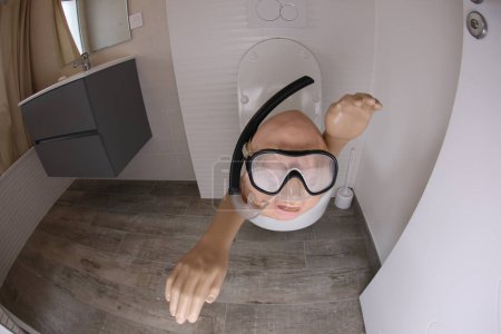 Téléchargez les photos : Wide angle shot of person with snorkel and diving mask sticking out of toilet, comedy concept - en image libre de droit
