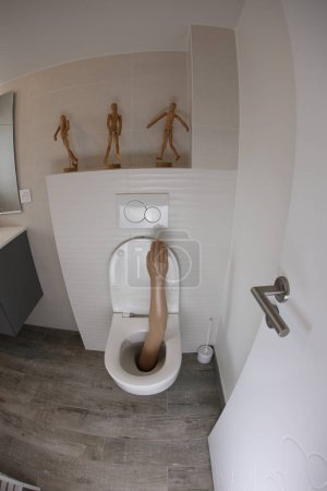 Foto de Wide angle shot of plastic arm sticking out of toilet - Imagen libre de derechos