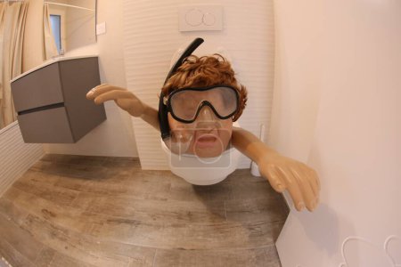 Foto de Plano de gran angular de la persona con snorkel y máscara de buceo que sobresale del inodoro, concepto de comedia - Imagen libre de derechos