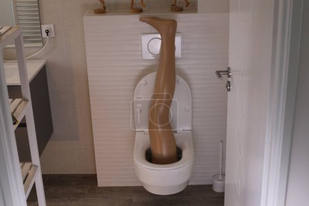 Foto de Wide angle shot of plastic leg sticking out of toilet - Imagen libre de derechos