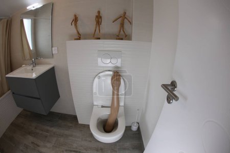 Téléchargez les photos : Wide angle shot of plastic arm sticking out of toilet - en image libre de droit