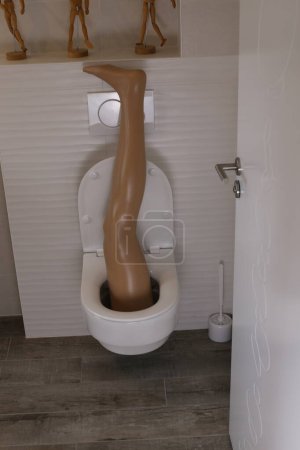 Photo for Wide angle shot of plastic leg sticking out of toilet - Royalty Free Image