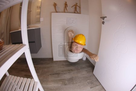 Téléchargez les photos : Plan grand angle de la personne avec un chapeau dur qui sort des toilettes, concept comique - en image libre de droit