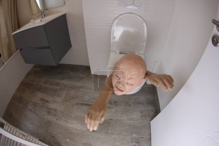 Téléchargez les photos : Wide angle shot of person sticking out of toilet, comedy concept - en image libre de droit
