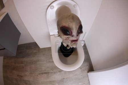 Téléchargez les photos : Plan grand angle de tête extraterrestre sortant des toilettes, concept comique - en image libre de droit
