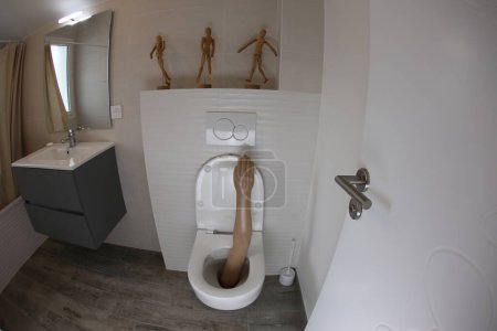 Téléchargez les photos : Wide angle shot of plastic arm sticking out of toilet - en image libre de droit