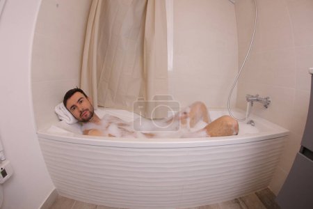 Téléchargez les photos : Plan grand angle de beau jeune homme dans le bain - en image libre de droit
