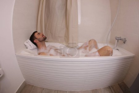 Téléchargez les photos : Wide angle shot of handsome young man in bath - en image libre de droit