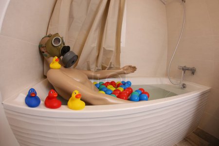 Téléchargez les photos : Wide angle shot of mannequin with gas mask in bath tub - en image libre de droit