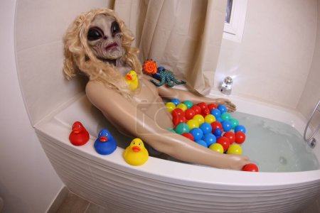 Foto de Wide angle shot of mannequin with alien head in bath tub - Imagen libre de derechos