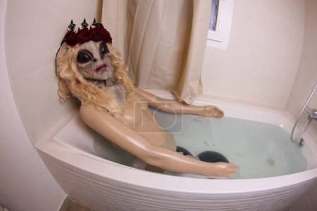 Téléchargez les photos : Plan grand angle de mannequin avec tête extraterrestre dans la baignoire - en image libre de droit