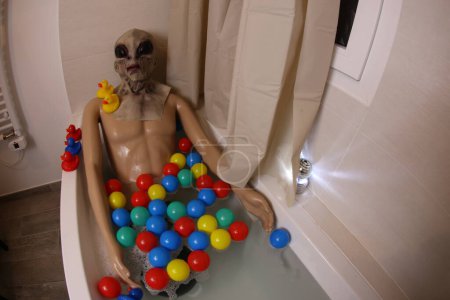 Téléchargez les photos : Plan grand angle de mannequin avec tête extraterrestre dans la baignoire - en image libre de droit