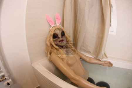 Foto de Gran ángulo de tiro de maniquí con cabeza alienígena en bañera - Imagen libre de derechos