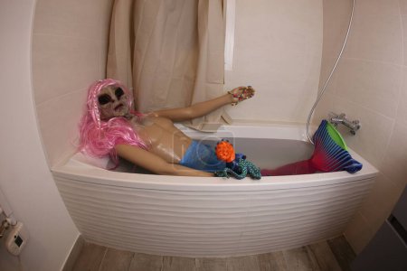 Téléchargez les photos : Wide angle shot of mannequin with alien head in bath tub - en image libre de droit