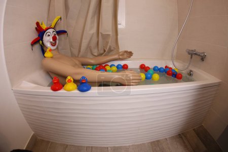 Téléchargez les photos : Plan grand angle de mannequin avec masque de clown et tête dans la baignoire - en image libre de droit