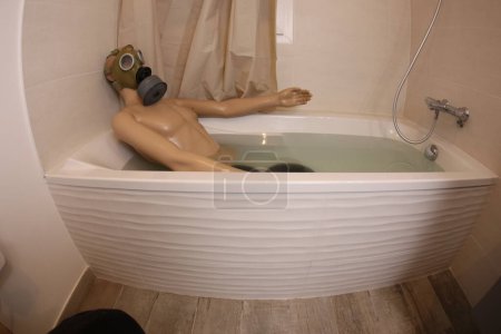 Téléchargez les photos : Wide angle shot of mannequin with gas mask in bath tub - en image libre de droit