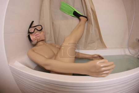 Photo for Wide angle shot of mannequin with snorkeling mask and flippers in bath tub - Royalty Free Image