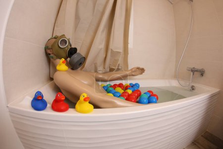 Téléchargez les photos : Plan grand angle de mannequin avec masque à gaz dans la baignoire - en image libre de droit