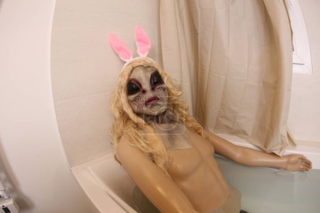 Foto de Wide angle shot of mannequin with alien mask in bath tub - Imagen libre de derechos