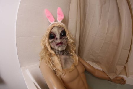 Téléchargez les photos : Plan grand angle de mannequin avec masque extraterrestre dans la baignoire - en image libre de droit