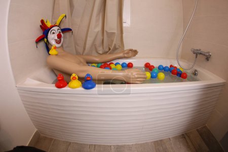 Photo for Wide angle shot of mannequin with clown mask in bath tub - Royalty Free Image
