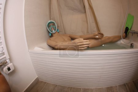 Foto de Gran angular de maniquí con máscara de snorkel y aletas en la bañera - Imagen libre de derechos