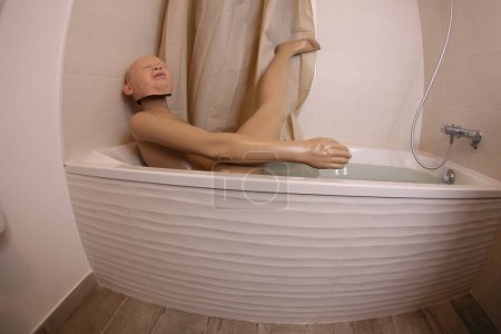 Photo for Wide angle shot of mannequin with crying baby mask in bath tub - Royalty Free Image