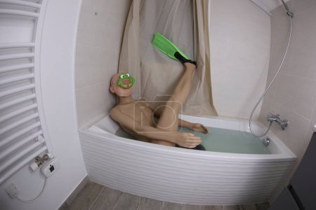Photo for Wide angle shot of mannequin with snorkeling mask and flippers in bath tub - Royalty Free Image