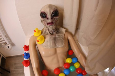 Photo for Wide angle shot of mannequin with alien mask in bath tub - Royalty Free Image