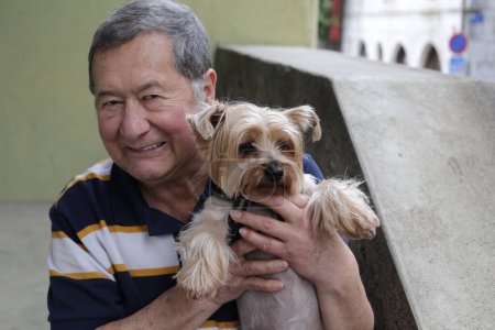 Téléchargez les photos : Portrait en gros plan d'un bel homme âgé avec son chien dans la rue - en image libre de droit