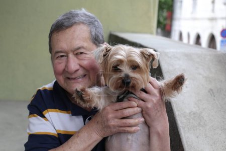 Téléchargez les photos : Portrait en gros plan d'un bel homme âgé avec son chien dans la rue - en image libre de droit