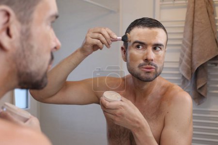 Foto de Retrato de hombre joven con vitiligo delante del espejo en el baño - Imagen libre de derechos