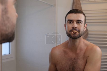 Foto de Retrato de hombre joven delante del espejo en el baño - Imagen libre de derechos