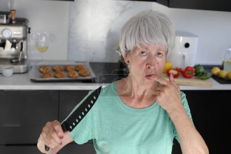 Photo for Close-up portrait of mature woman with knife at kitchen - Royalty Free Image