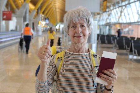 Photo for Close-up portrait of mature woman with passport at airport - Royalty Free Image