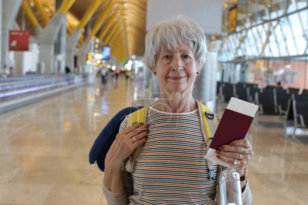 Téléchargez les photos : Portrait en gros plan de femme mûre avec passeport à l'aéroport - en image libre de droit