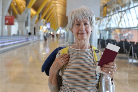 Foto de Primer plano retrato de mujer madura con pasaporte en el aeropuerto - Imagen libre de derechos